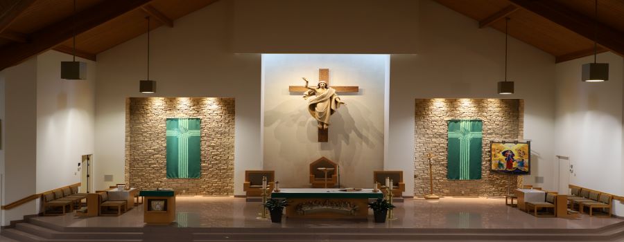View of St. Leonard's Altar with large cross and the Risen Jesus and green banners to either side of the altar
