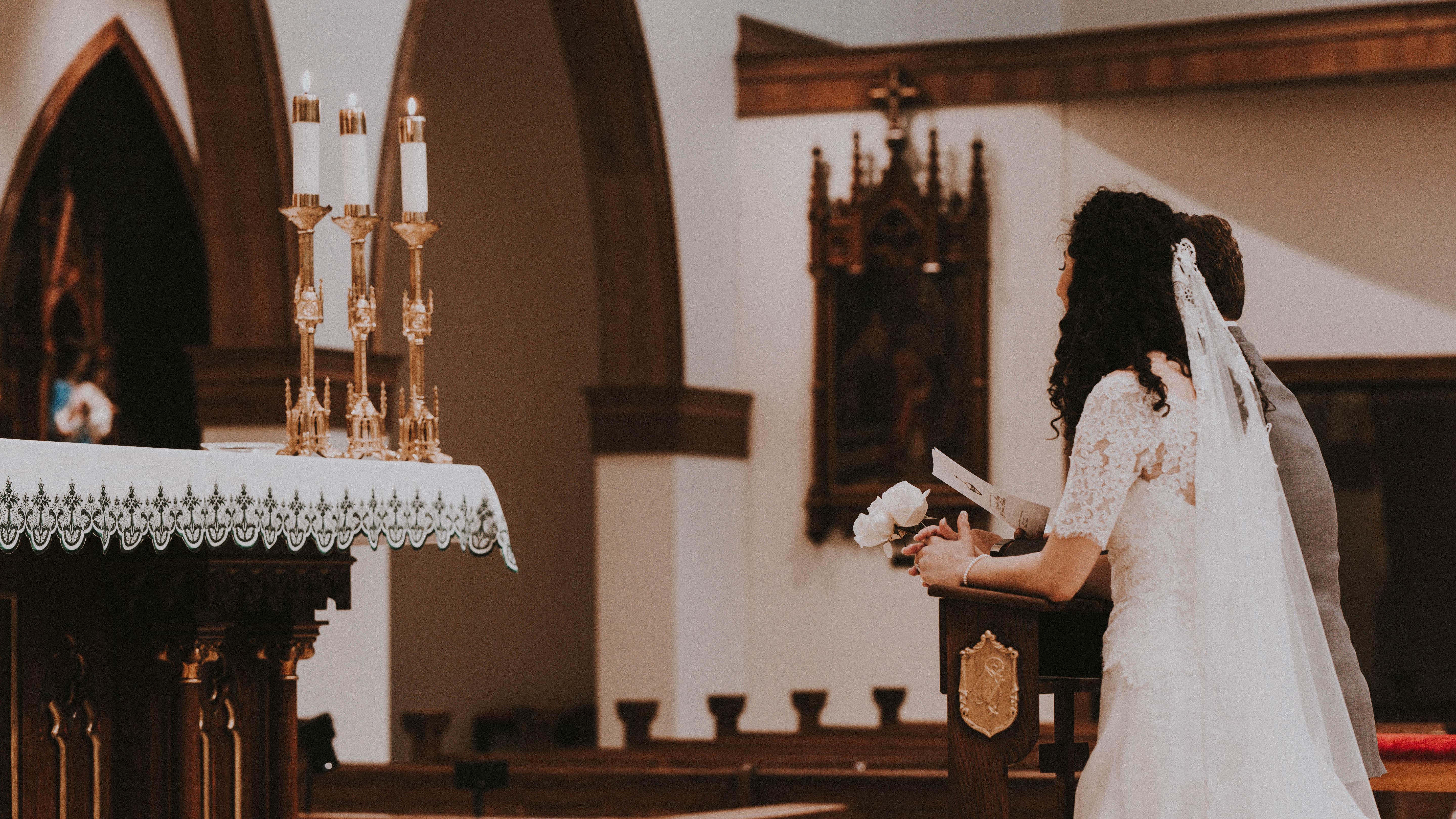 Couple kneeling at the altar at their wedding