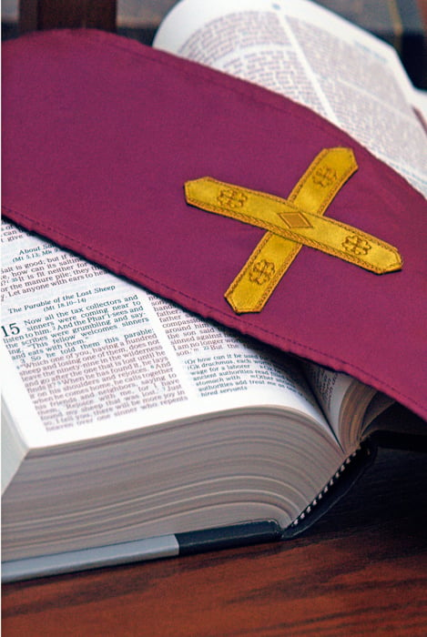 Bible open with a priest's purple stole over it